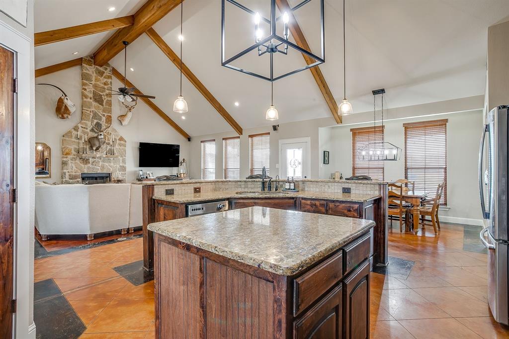 160 Goodnight Trail Rhome, TX 76078 - Photo 39 of 40 a kitchen with stainless steel appliances granite countertop a sink counter space and a window