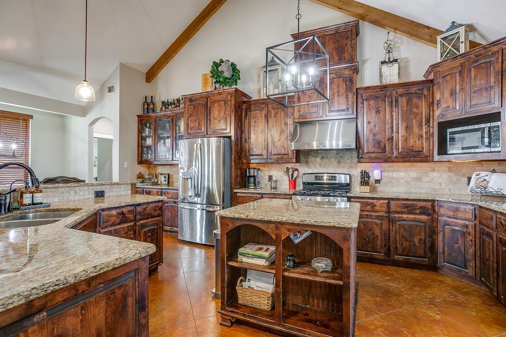 160 Goodnight Trail Rhome, TX 76078 - Photo 12 of 40 a kitchen with stainless steel appliances granite countertop a sink stove and refrigerator