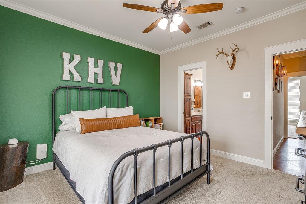 160 Goodnight Trail Rhome, TX 76078 - Photo 20 of 40 a bedroom with a large bed and a chandelier