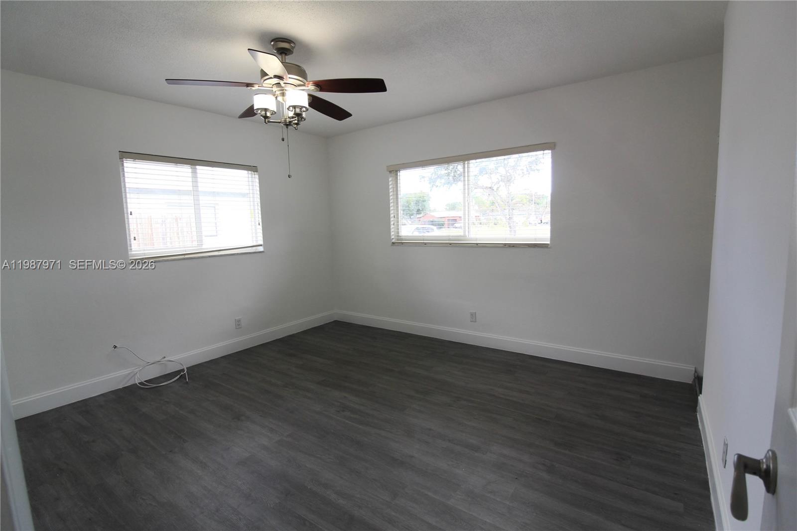 5160 Southwest 8th Street Margate, FL 33068 - Photo 16 of 23 an empty room with wooden floor chandelier fan and windows