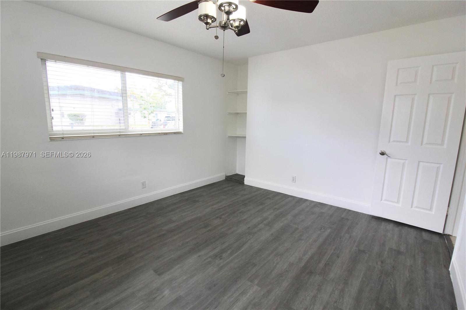 5160 Southwest 8th Street Margate, FL 33068 - Photo 7 of 23 an empty room with wooden floor chandelier and window