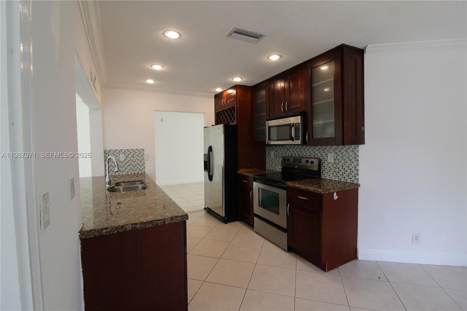 5160 Southwest 8th Street Margate, FL 33068 - Photo 9 of 23 a kitchen with a sink and a stove top oven with wooden floor