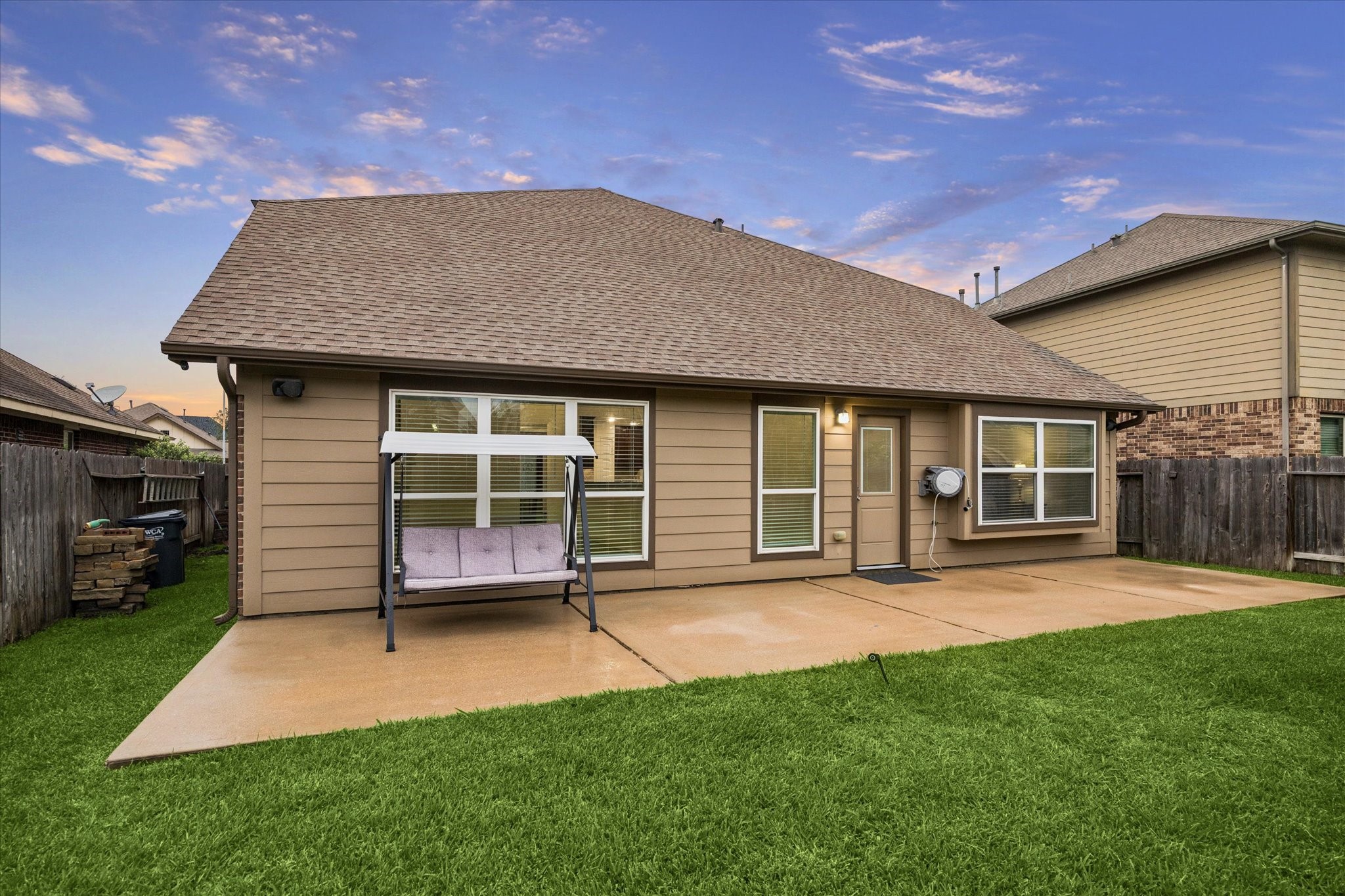 7015 Riata Hills Lane Spring, TX 77379 - Photo 29 of 33 A reverse view of the backyard toward the home highlights the expansive patio slab, ideal for outdoor lounging, dining, and entertaining with a BBQ setup.