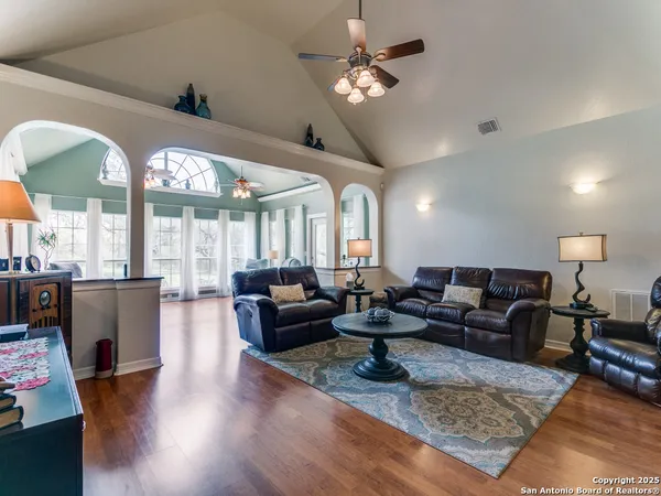 a living room with furniture chandelier and a large window