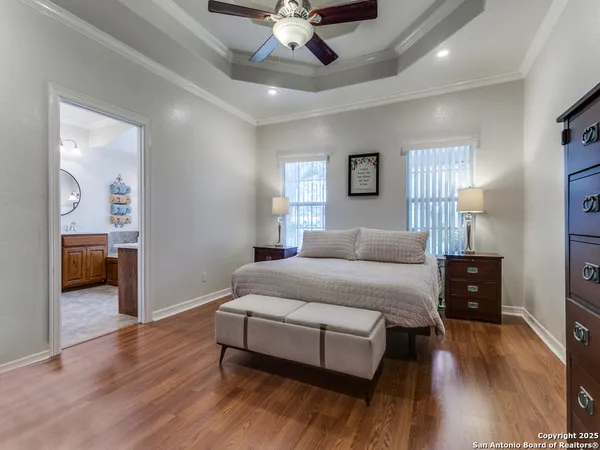 a spacious bedroom with a bed and wooden floor