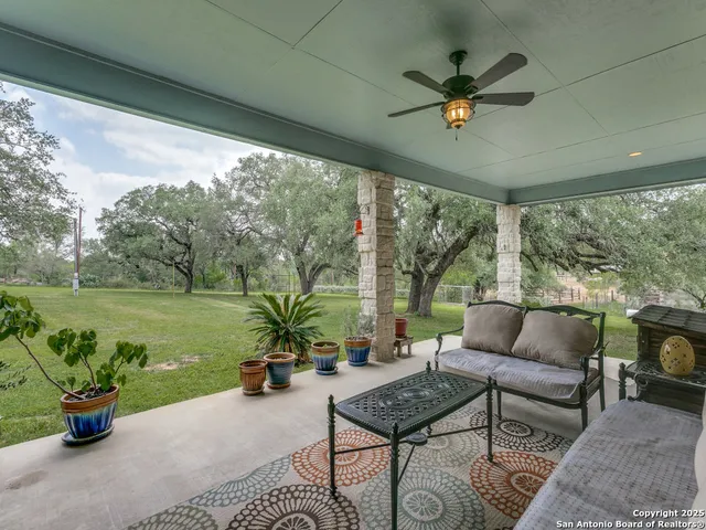 a living room with patio furniture and a garden