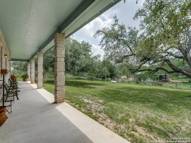 a view of a porch with chairs and a yard