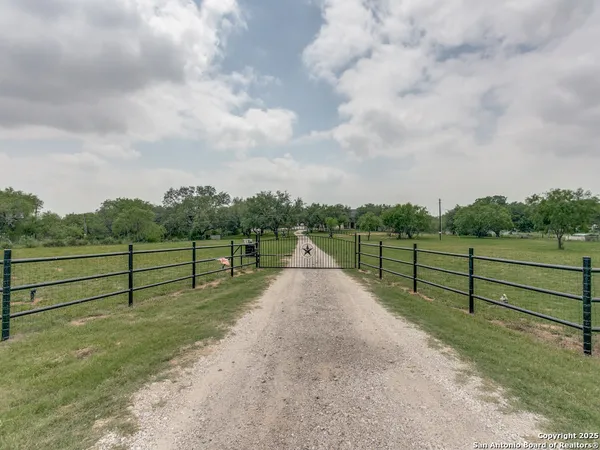 a view of a yard with wooden fence