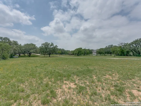 a view of a green field with wooden fence