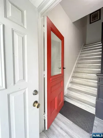 a view of a hallway with entryway wooden floor and front door