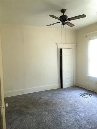 an empty room with a window and a fan