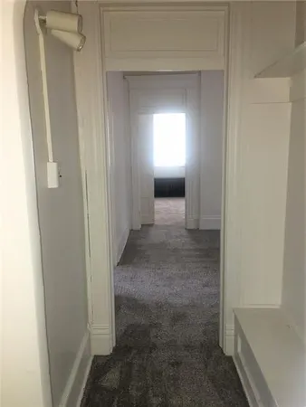 a view of a hallway with wooden floor and closet