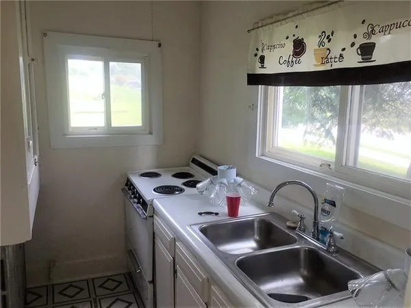 a kitchen with a sink cabinets and a window