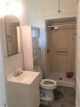 a bathroom with a toilet sink vanity and shower