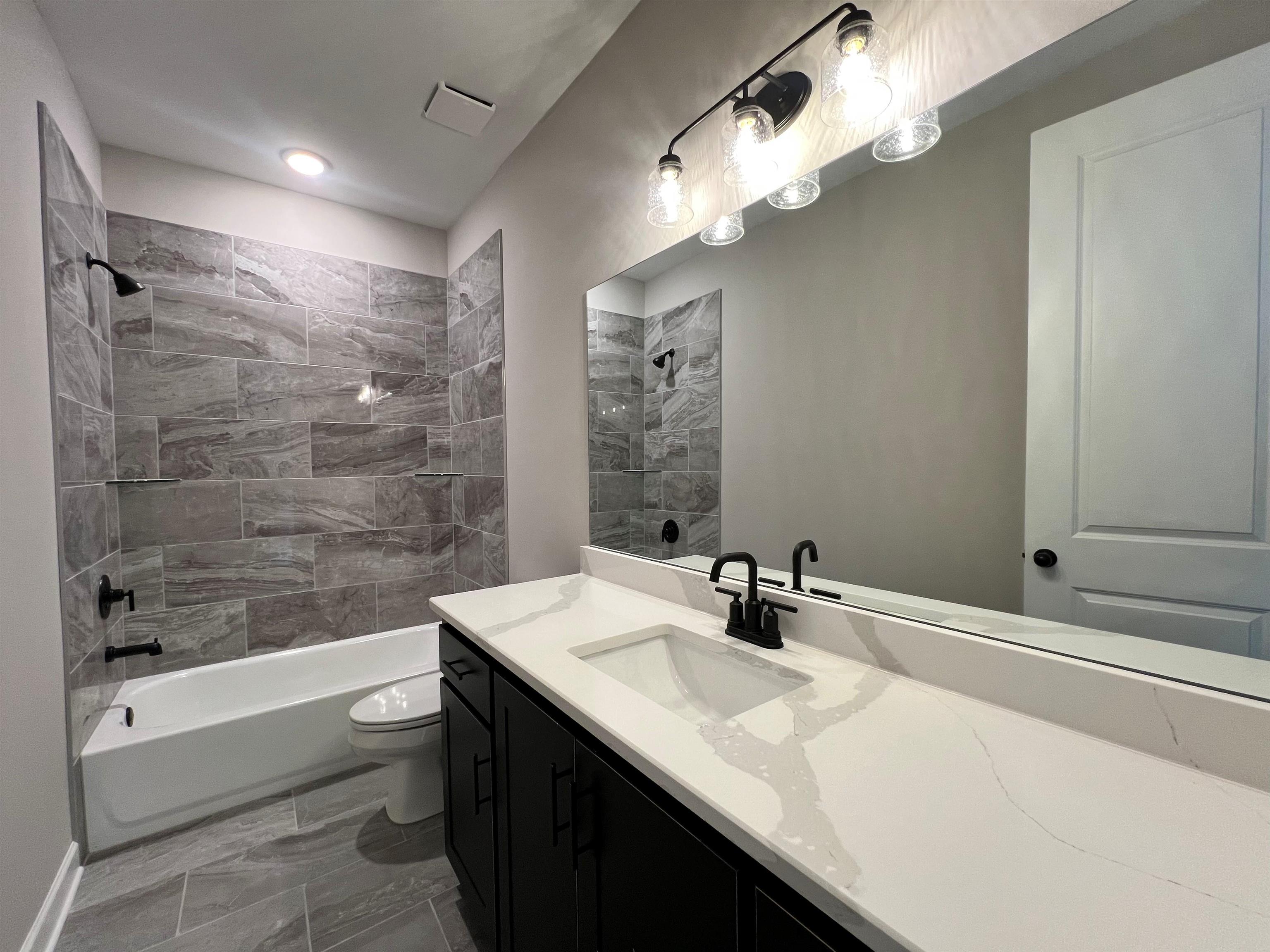 220 Drake Drive Collierville, TN 38017 - Photo 19 of 30 a bathroom with a sink a toilet a mirror a bathtub and shower