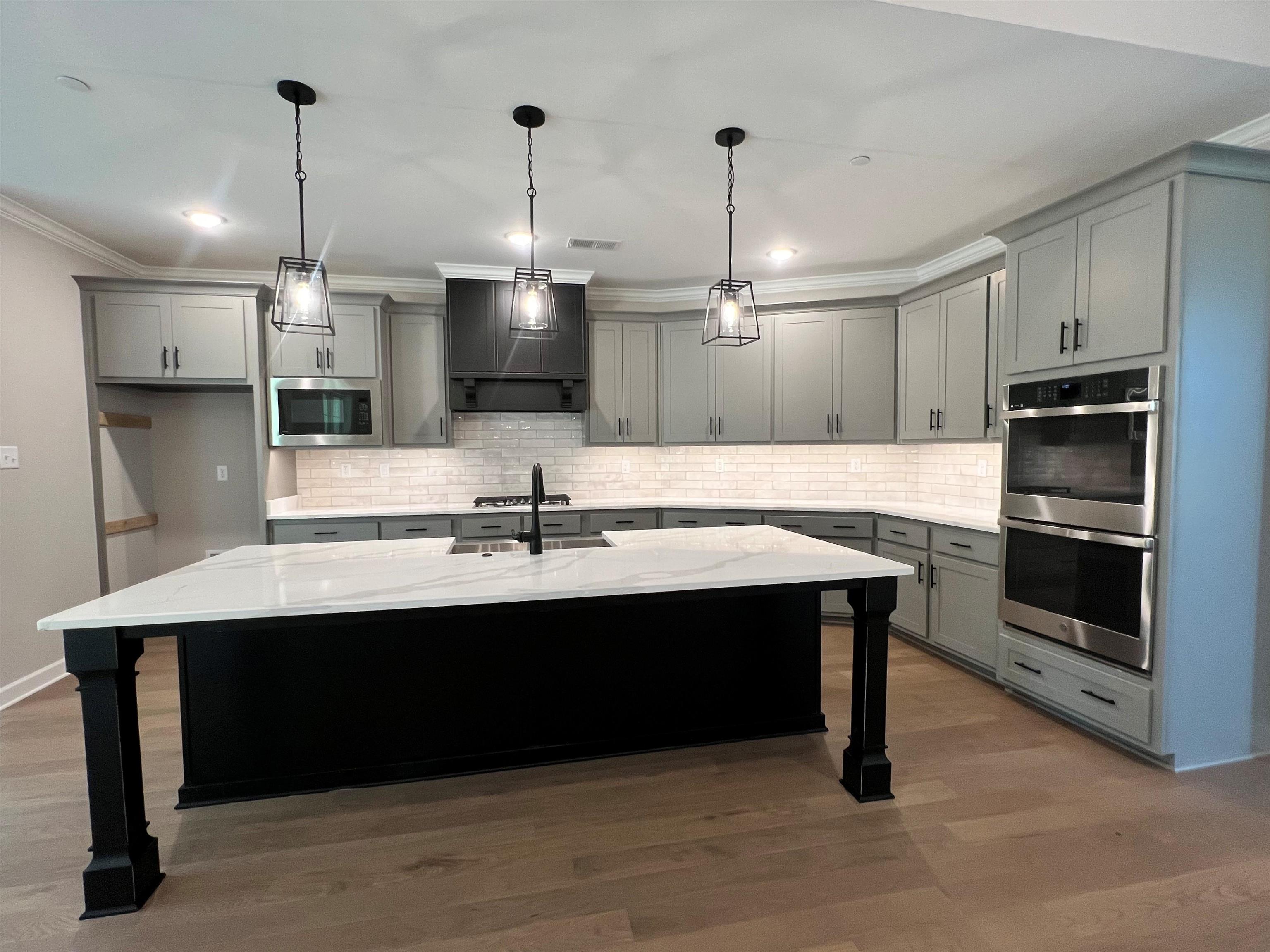 220 Drake Drive Collierville, TN 38017 - Photo 3 of 30 a kitchen with kitchen island a sink stainless steel appliances and cabinets