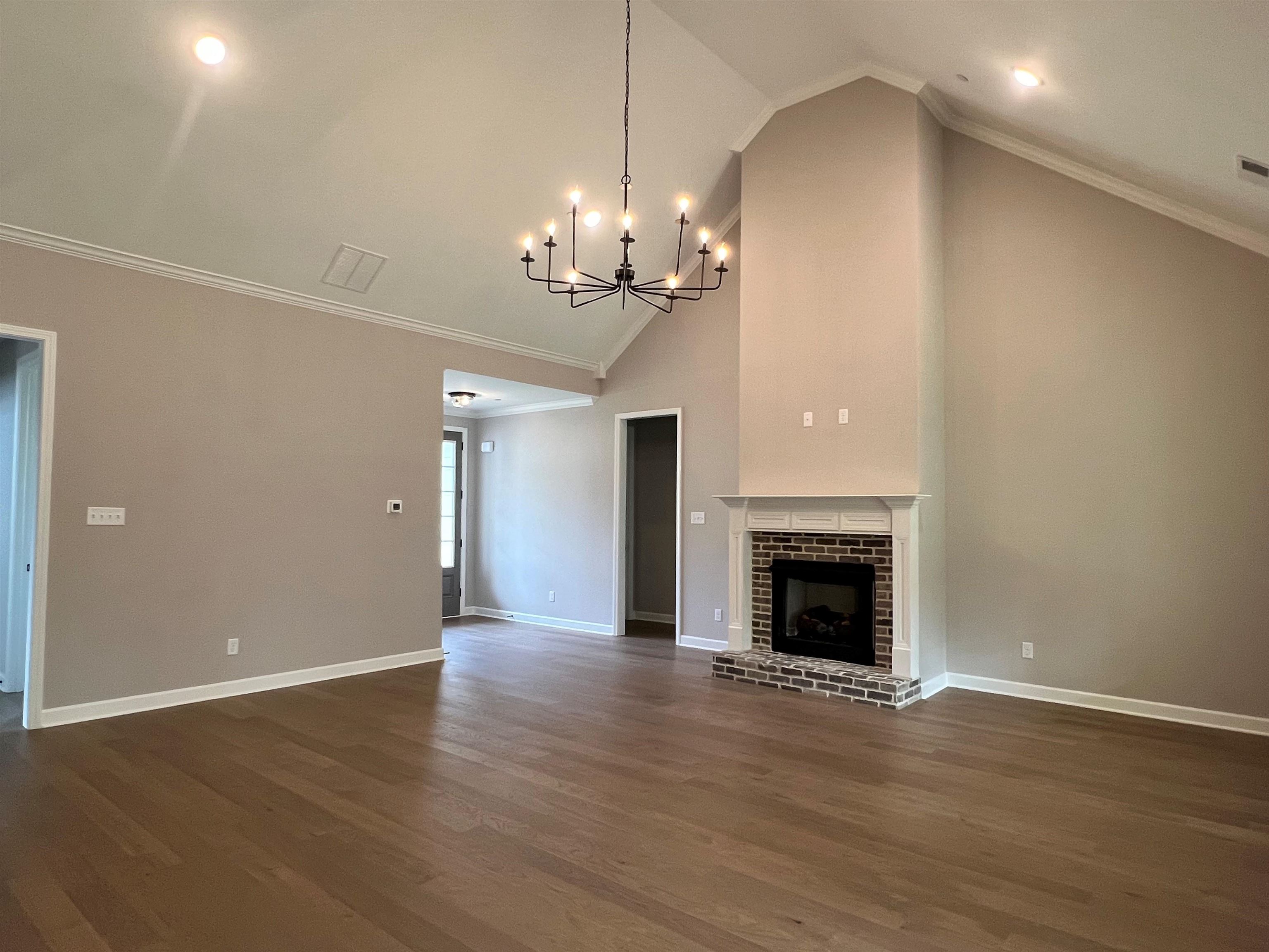220 Drake Drive Collierville, TN 38017 - Photo 7 of 30 a view of a livingroom with a fireplace a chandelier and wooden floor