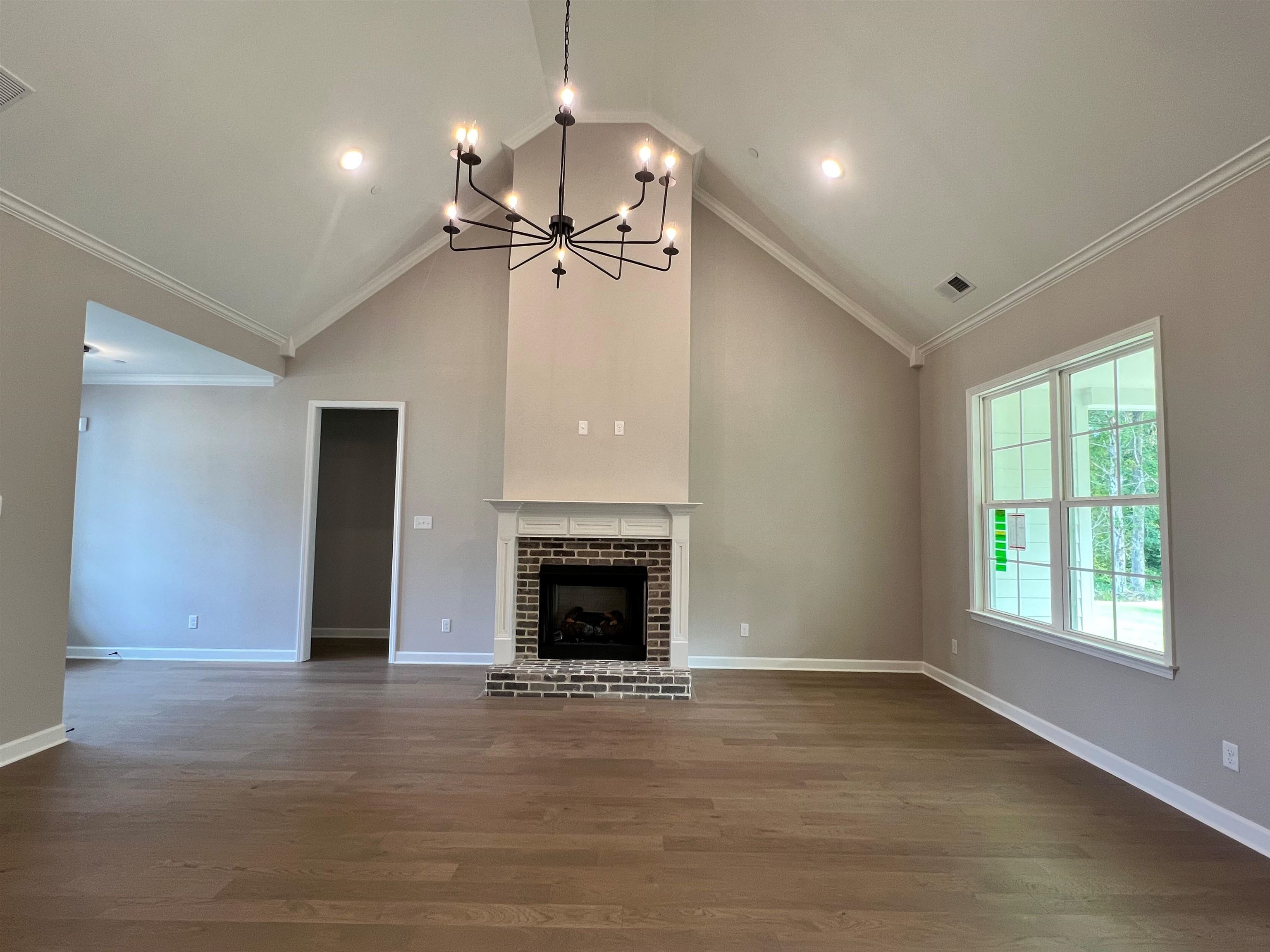 220 Drake Drive Collierville, TN 38017 - Photo 8 of 30 an empty room with wooden floor fireplace and windows