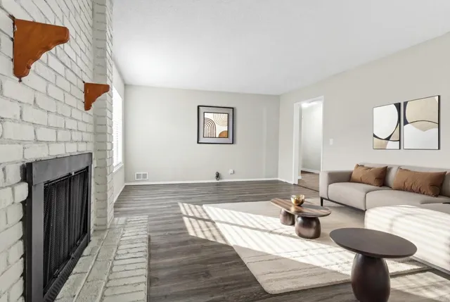 an empty room with wooden floor and a fireplace