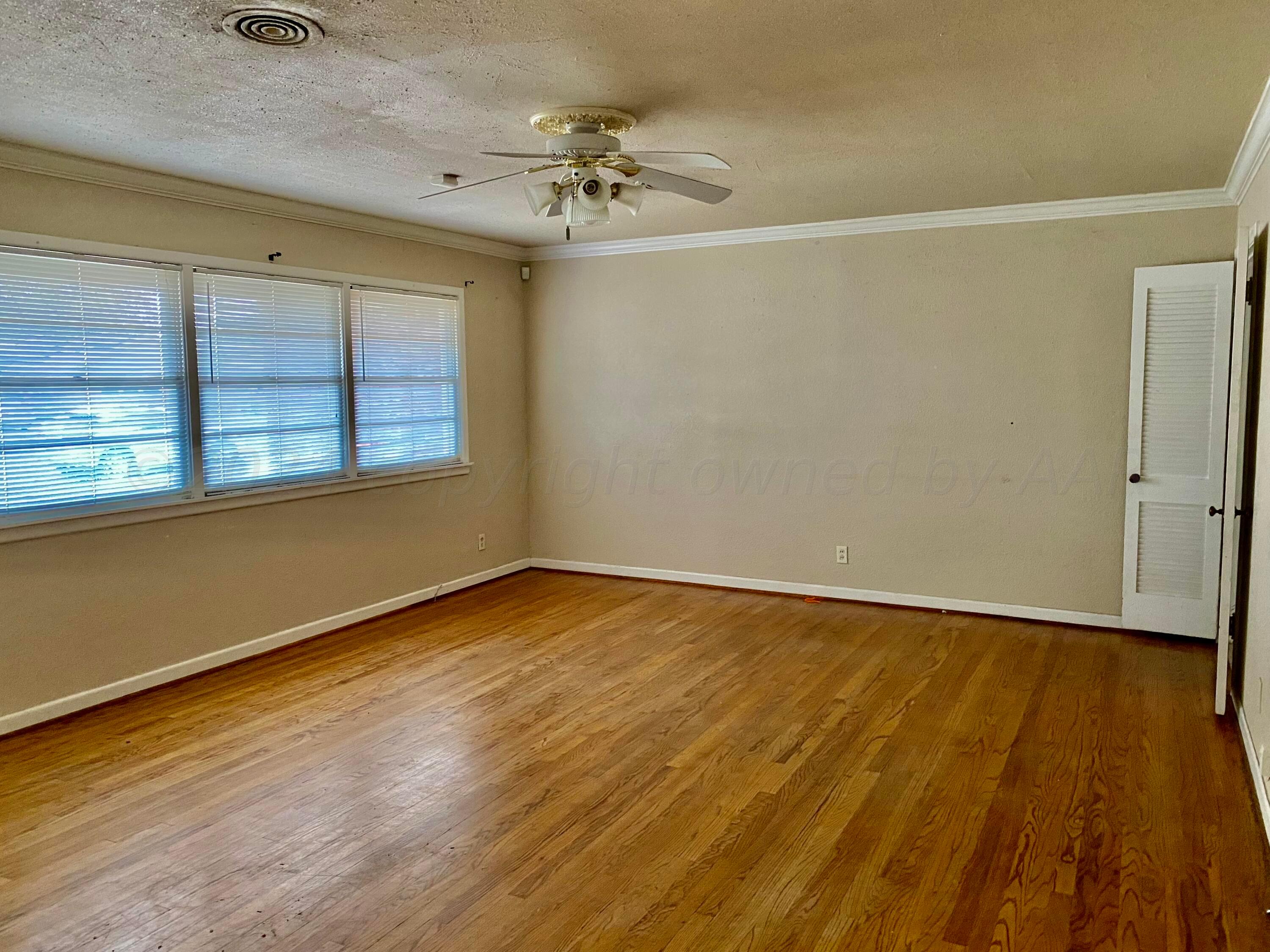 3309 Paramount Boulevard Amarillo, TX 79109 - Photo 3 of 26 a view of an empty room with wooden floor and a window