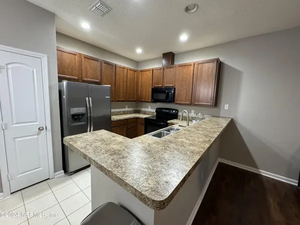 a kitchen with stainless steel appliances granite countertop refrigerator sink and cabinets