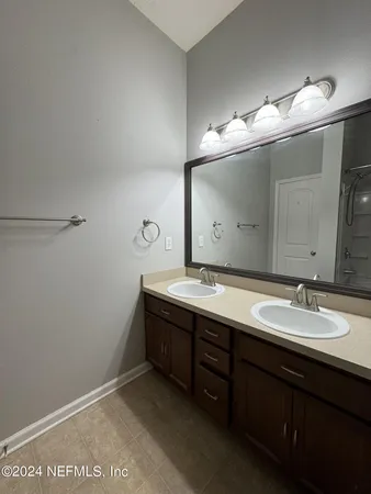 a bathroom with a double vanity sink and a mirror