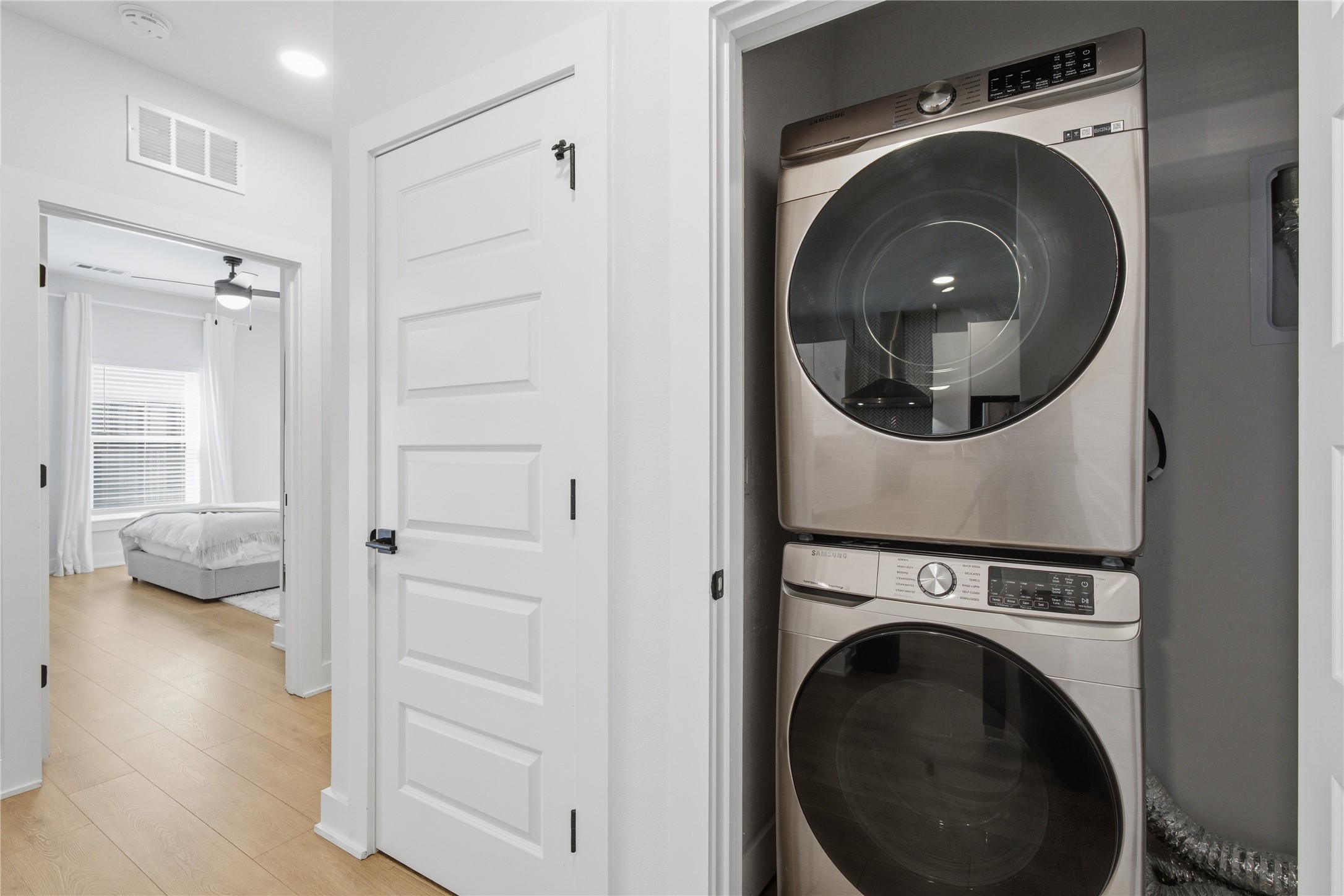 2500 Longview Street, Unit 219 Austin, TX 78705 - Photo 13 of 40 Washroom with stacked washer / dryer, light wood-style floors, and ceiling fan