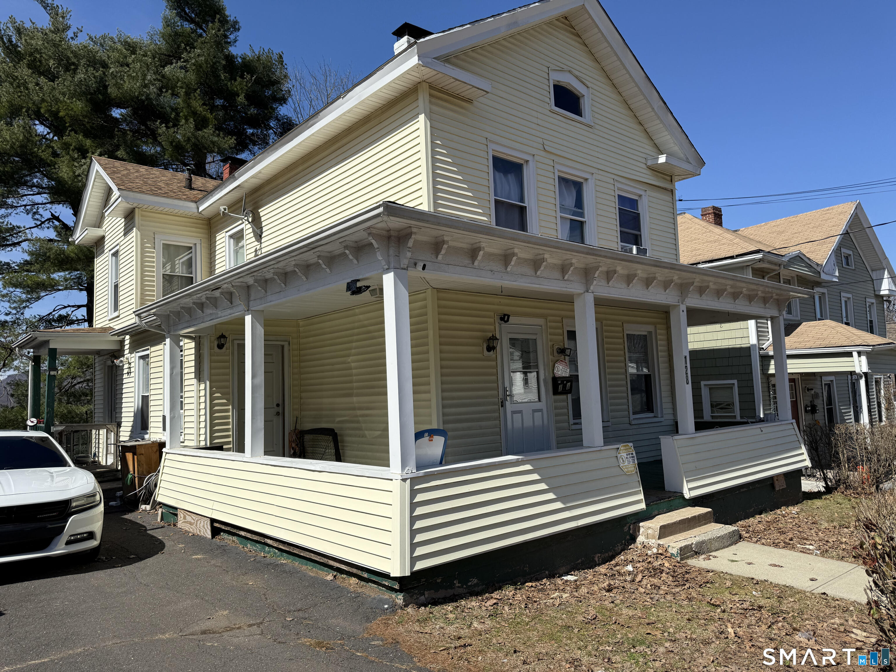 128 Hobart Street Meriden, CT 06450 - Photo 3 of 15 a view of a white house with large windows and a table and chairs