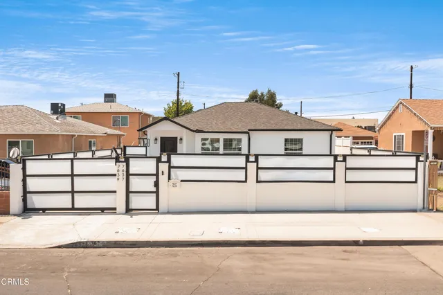 a white house that has a street sign on it