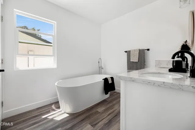 a white bath tub sitting next to a bathroom sink