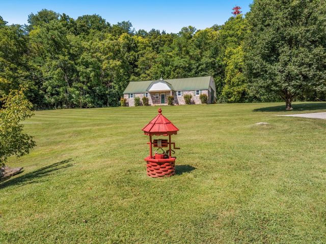 a living room with furniture a flat screen tv and a large window