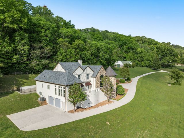 an aerial view of residential houses with outdoor space and trees