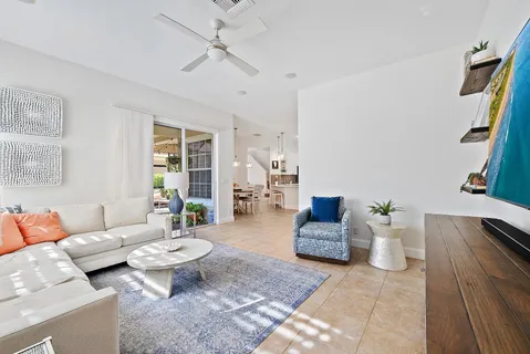 a spacious bedroom with a bed a couch and a chandelier
