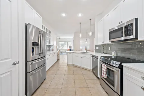a view of a dining room and livingroom with furniture wooden floor a chandelier