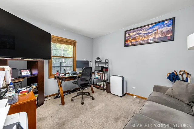 a view of a workspace with furniture and a window