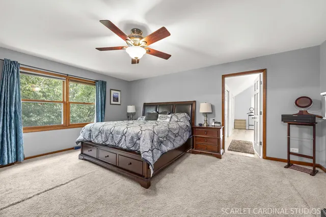 a spacious bedroom with a large bed and a chandelier fan