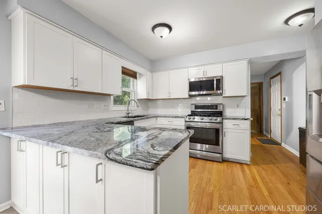 a kitchen with granite countertop a sink and steel appliances