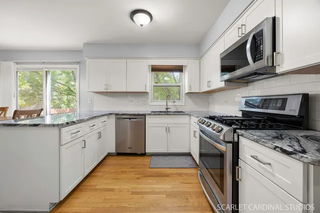 a kitchen with stainless steel appliances granite countertop a stove a sink and a microwave