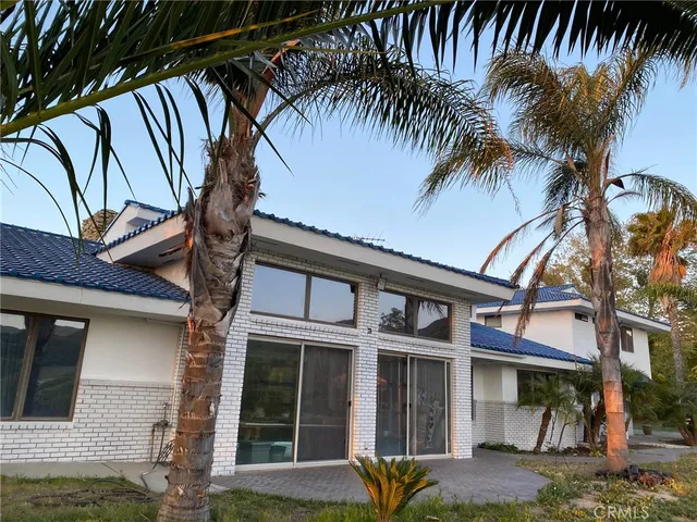 a front view of a house with a tree