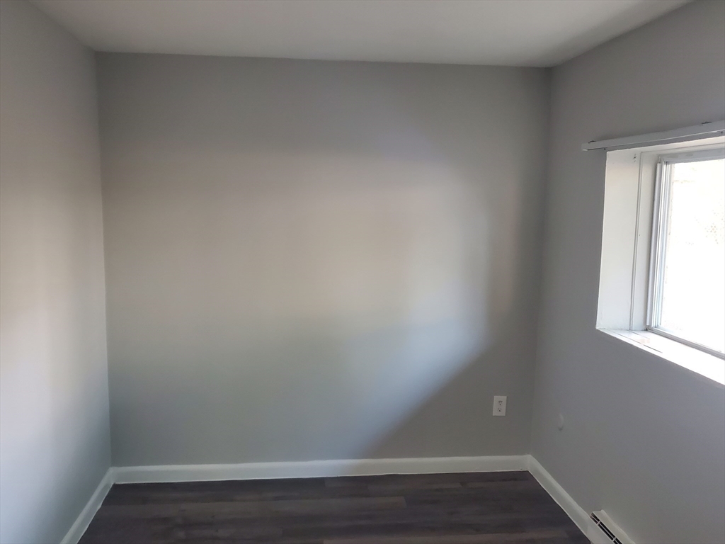 760 Cummins Highway, Unit 4 Boston, MA 02126 - Photo 12 of 12 a view of an empty room and wooden floor