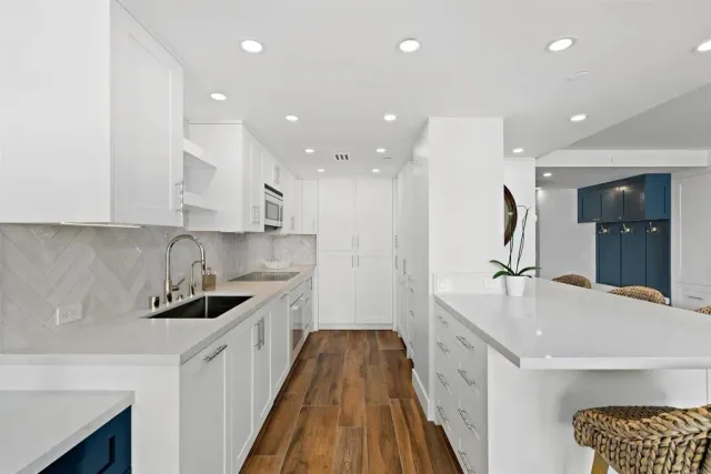 a kitchen with kitchen island a sink and wooden floor