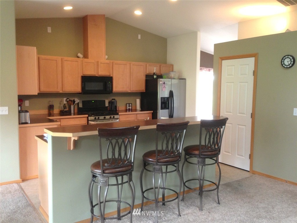 356 Yates Road Chehalis, WA 98532 - Photo 7 of 21 a kitchen with a dining table chairs and a refrigerator
