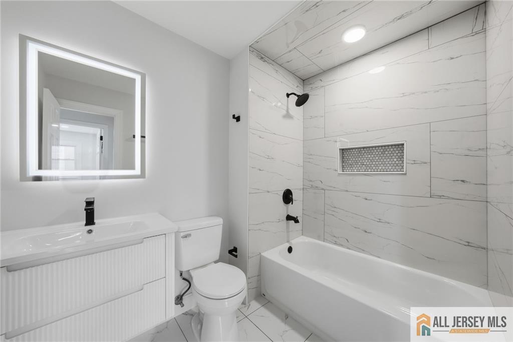 6 Wilton Avenue Middlesex, NJ 08846 - Photo 18 of 50 a bathroom with a toilet a sink a mirror and bathtub
