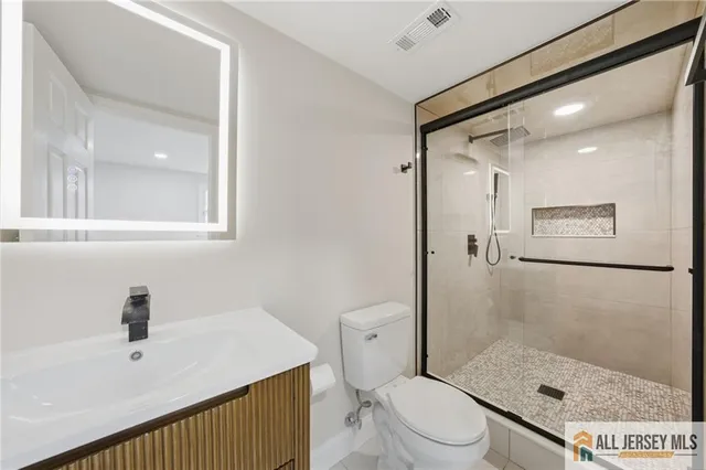 a bathroom with a sink a toilet and shower