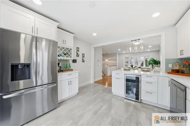 a kitchen with white cabinets and stainless steel appliances