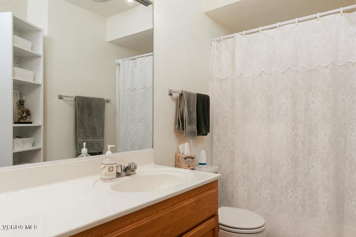 2901 Peninsula Road, Unit 237 Oxnard, CA 93035 - Photo 14 of 35 a bathroom with a sink a toilet a mirror and shower curtain