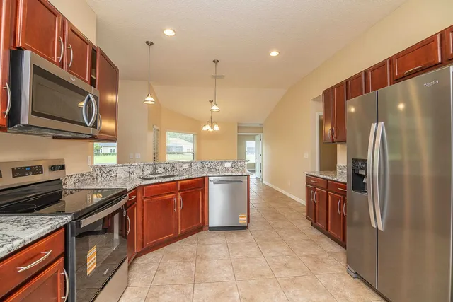 an empty room with windows and chandelier