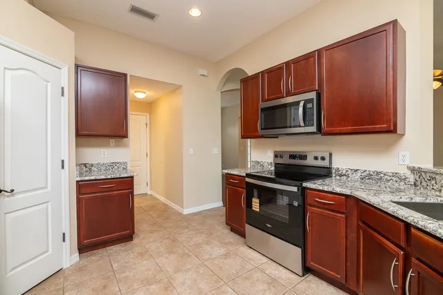 a kitchen with stainless steel appliances granite countertop a refrigerator and a sink