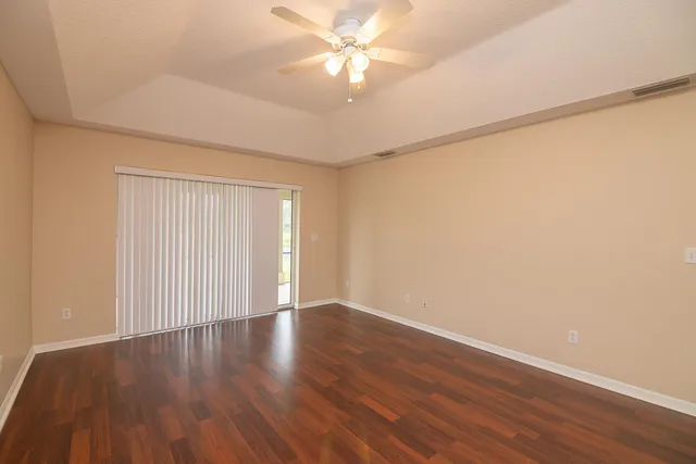 an empty room with wooden floor and window
