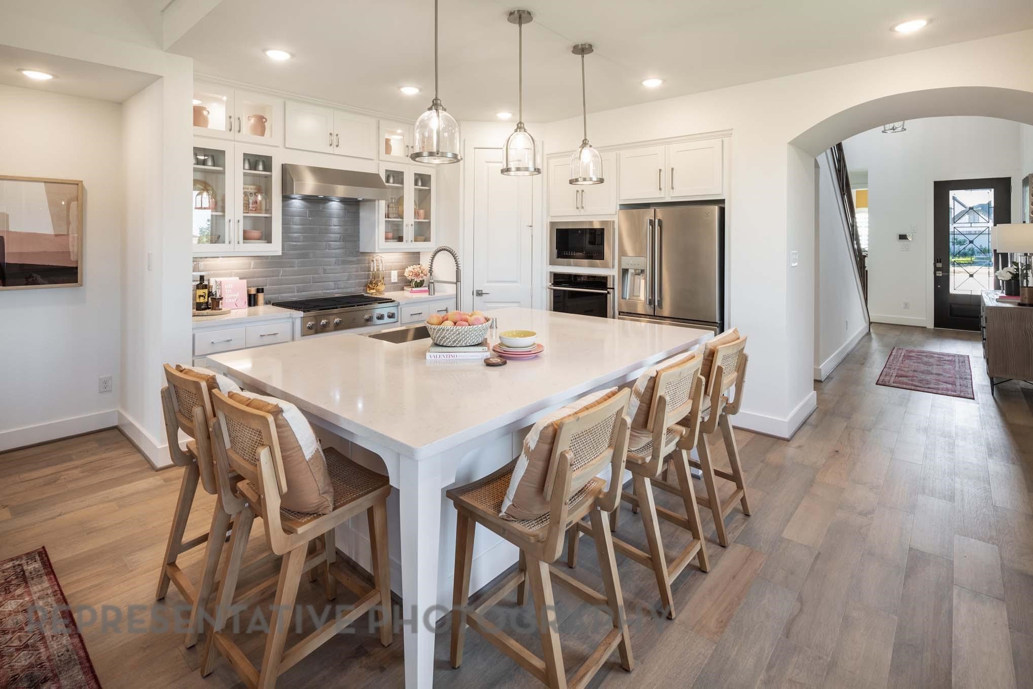 5310 Getty Lane Manvel, TX 77578 - Photo 6 of 37 a kitchen with stainless steel appliances kitchen island granite countertop a dining table chairs and a refrigerator